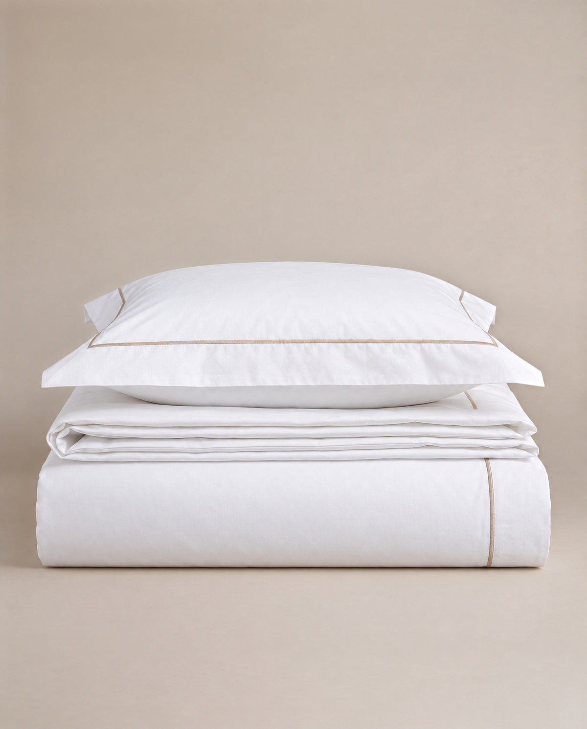White percale with champagne embroidery — a warmer signature.