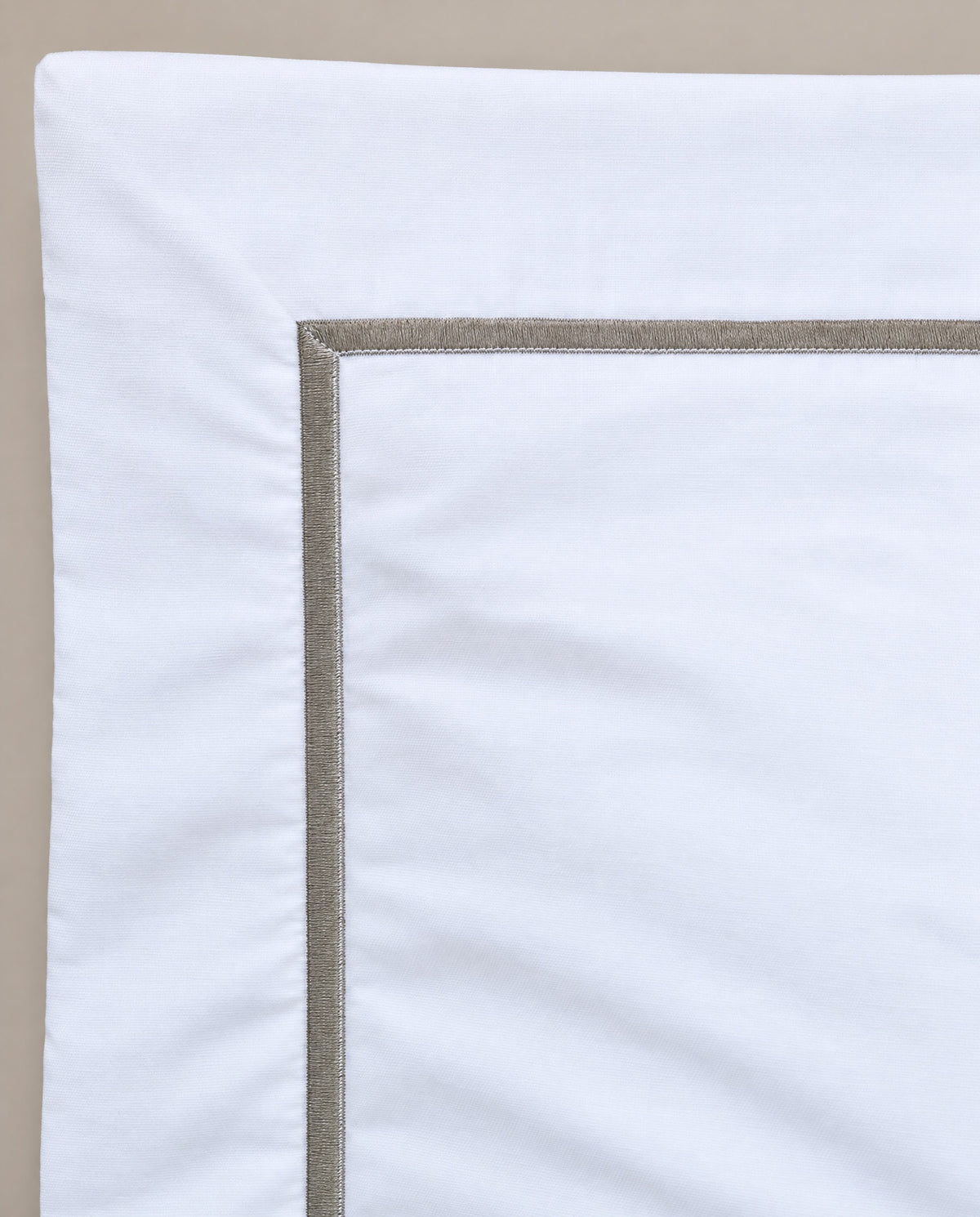 Green embroidery on white — up close.