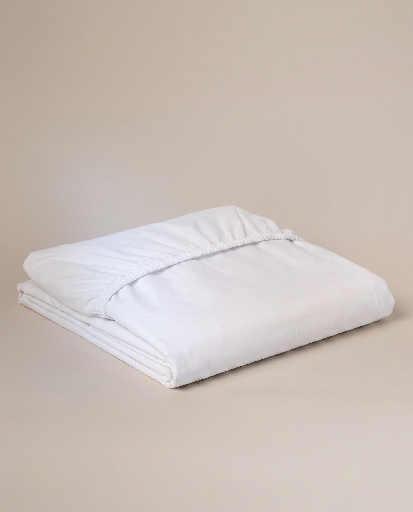 Fitted sheet in white percale — all-round elastic, taut night after night.
